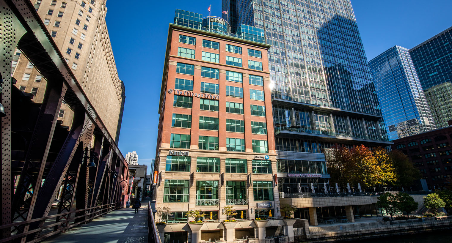 exterior view of a multi-story brick building along a river