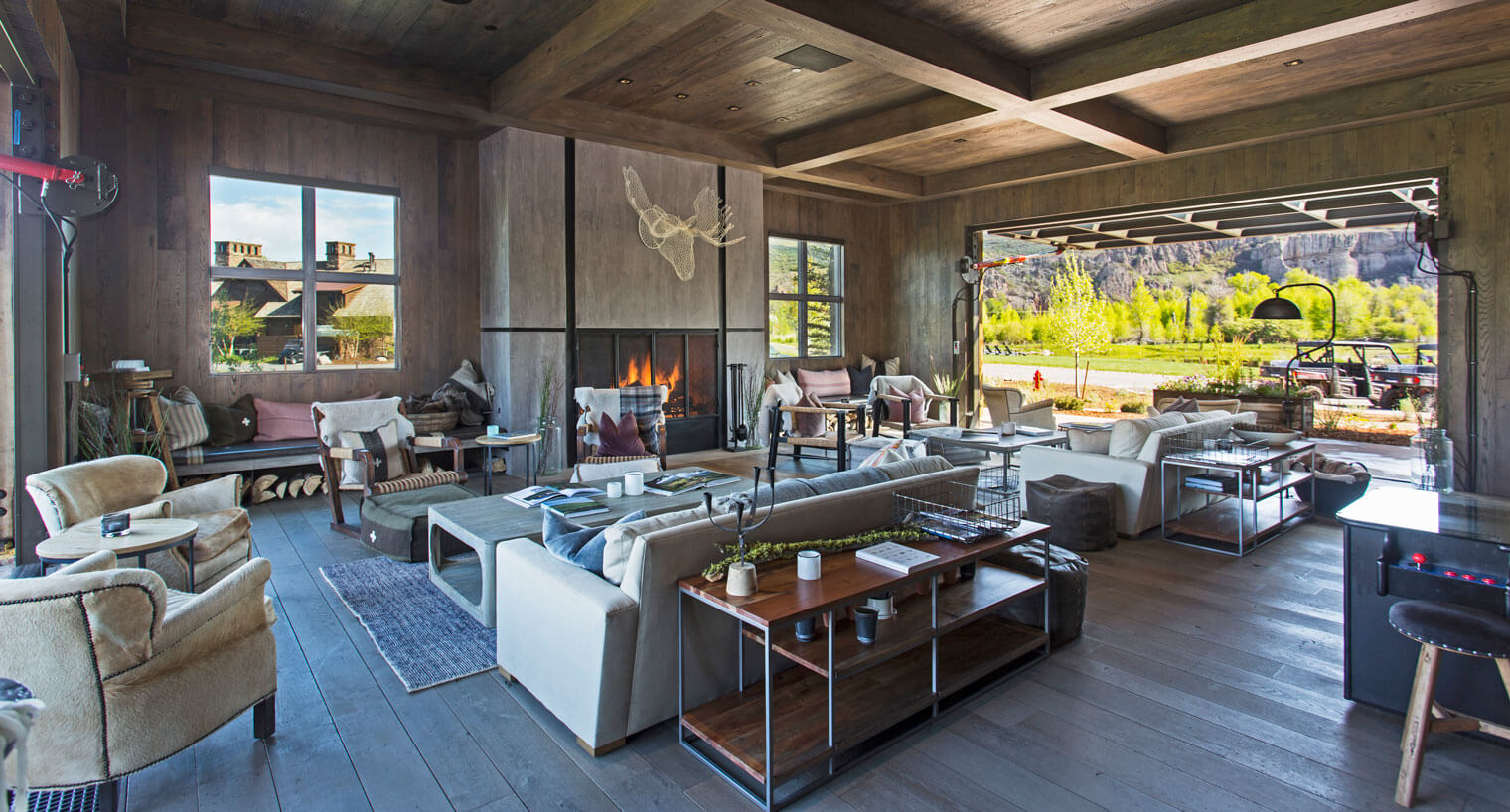 entertainment room with couches, fireplace and glass garage door