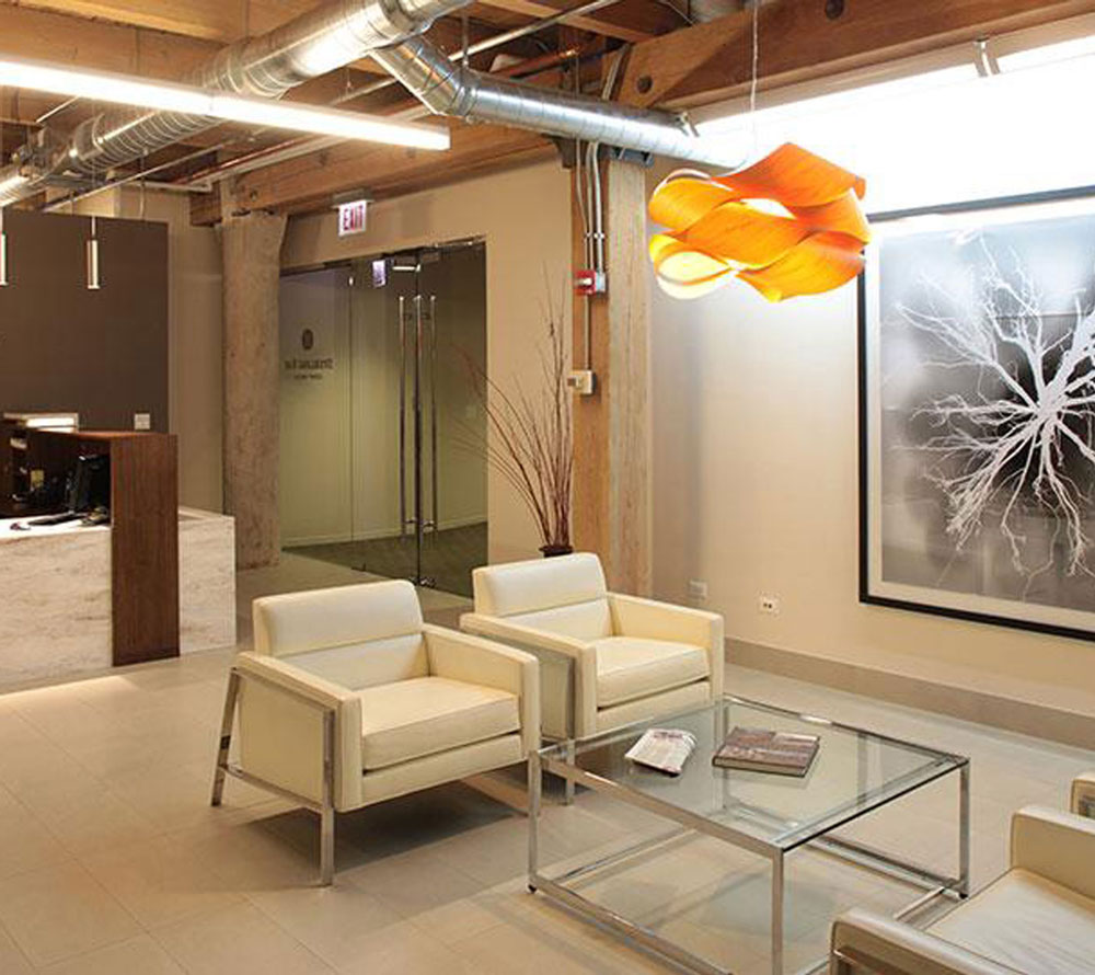 Waiting area with white leather armchairs near reception desk