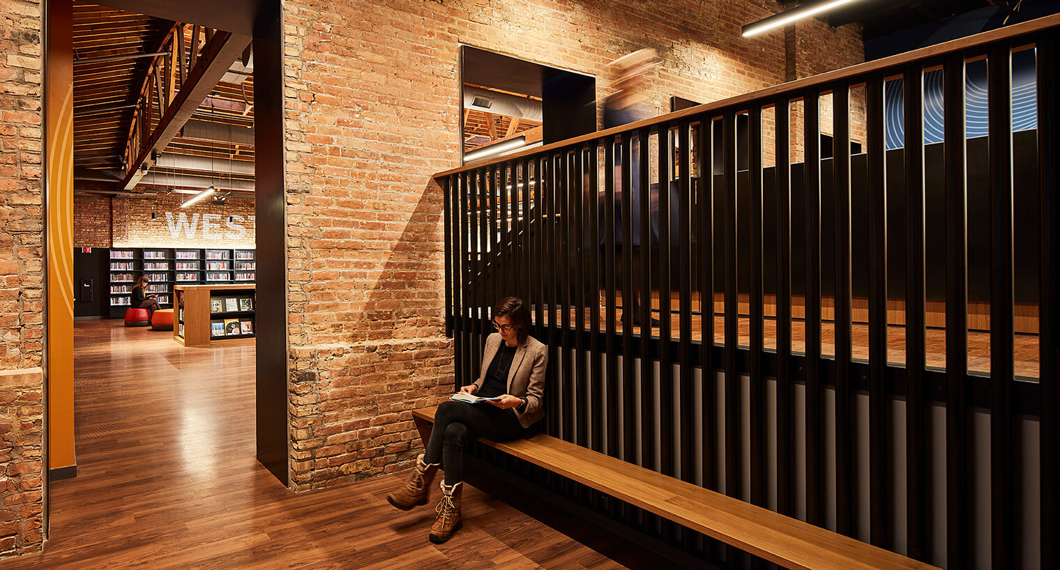 a women reading in a library designed with exposed brick