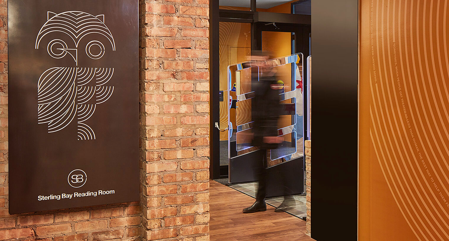exposed brick wall with a black sterling bay reading room sign