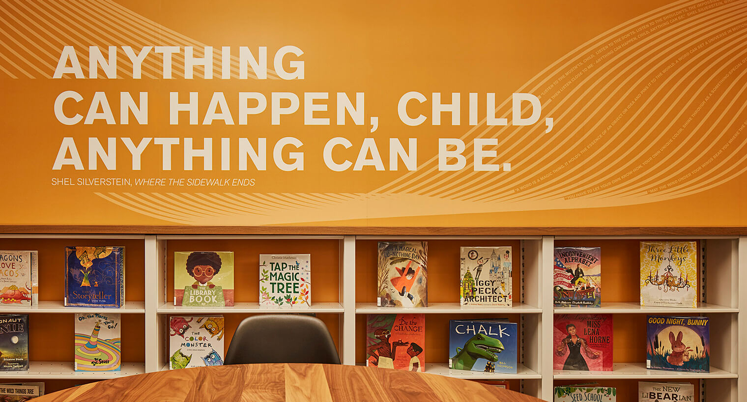 painted orange wall with quote in a childerens reading room